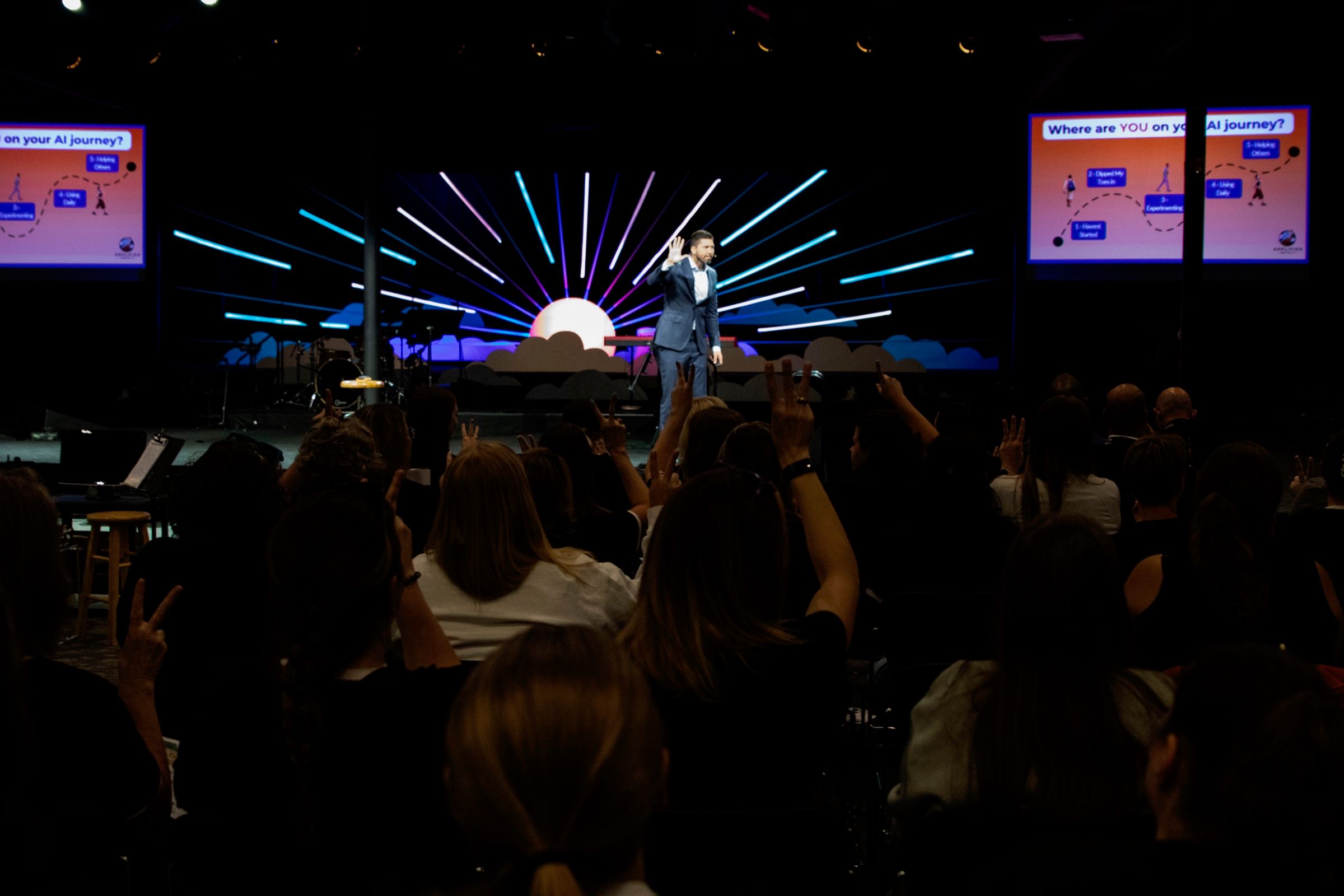Tyler Moberg delivering a keynote on a brightly lit stage in front of a seated audience.
