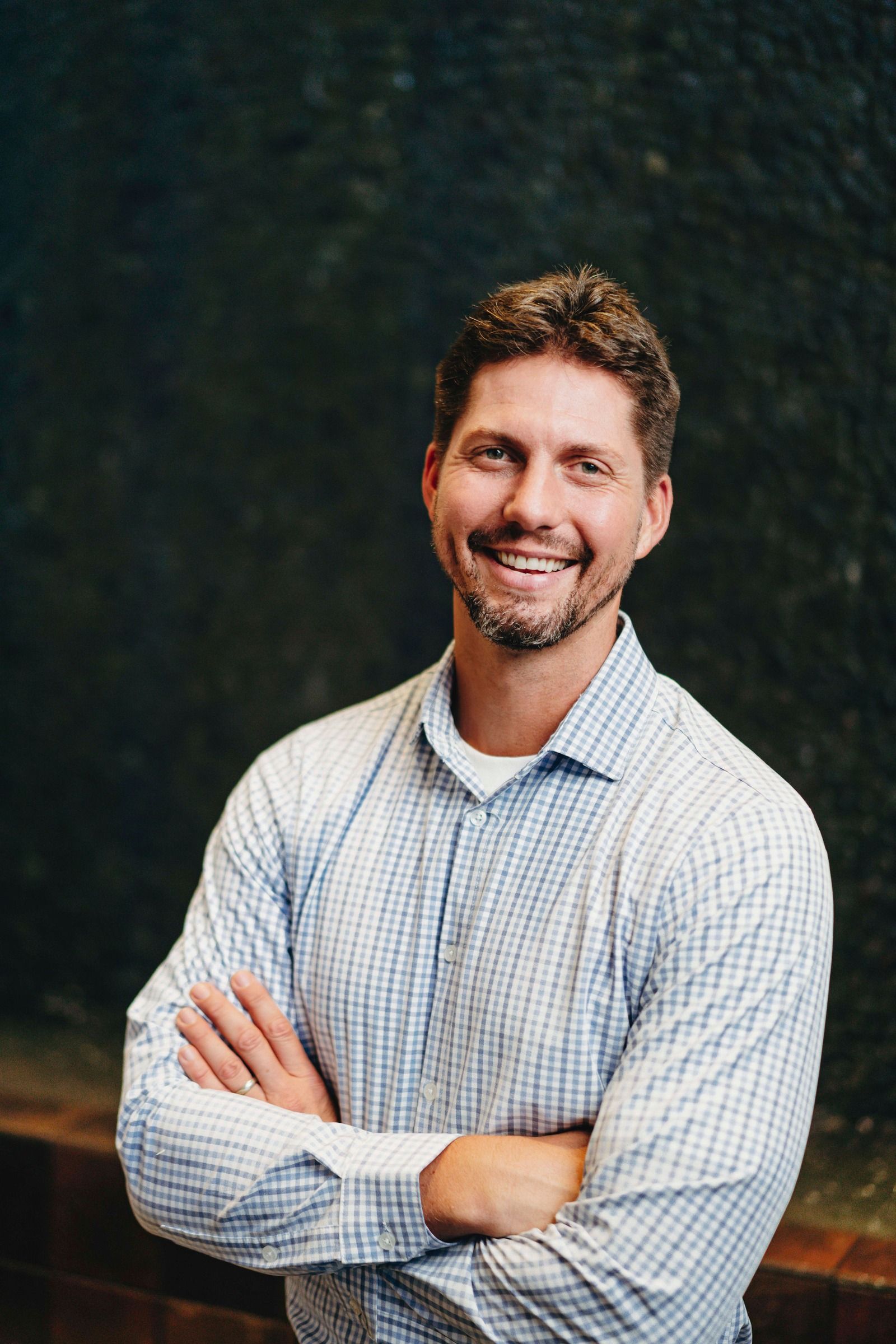 Portrait of Tyler Moberg, founder of Amplified Impact, smiling in a checked shirt.
